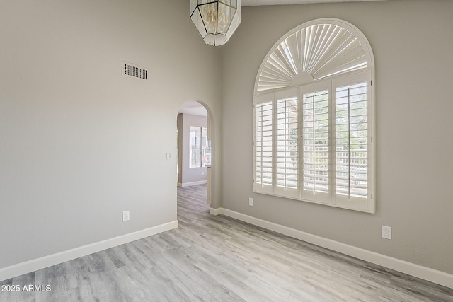 4627 E Mcneil St, Phoenix, AZ 85044 - spare room with arched walkways, plenty of natural light, and wood finished floors