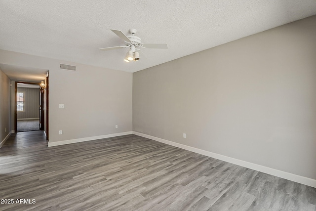 4627 E Mcneil St, Phoenix, AZ 85044 - unfurnished room with wood finished floors, a ceiling fan, baseboards, and a textured ceiling