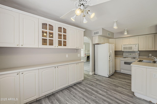 4627 E Mcneil St, Phoenix, AZ 85044 - kitchen with white appliances, arched walkways, a sink, ceiling fan, and glass insert cabinets