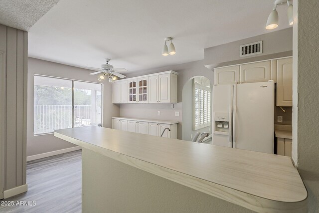 4627 E Mcneil St, Phoenix, AZ 85044 - kitchen with white refrigerator with ice dispenser, glass insert cabinets, ceiling fan, light wood-type flooring, and arched walkways