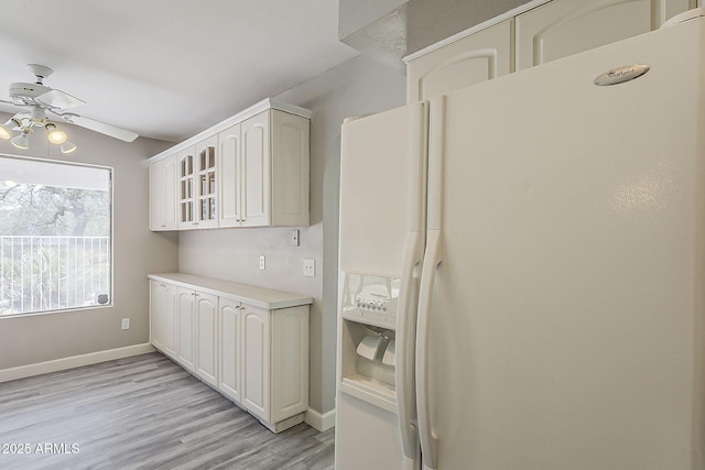 4627 E Mcneil St, Phoenix, AZ 85044 - kitchen featuring white fridge with ice dispenser, ceiling fan, glass insert cabinets, light wood finished floors, and white cabinetry