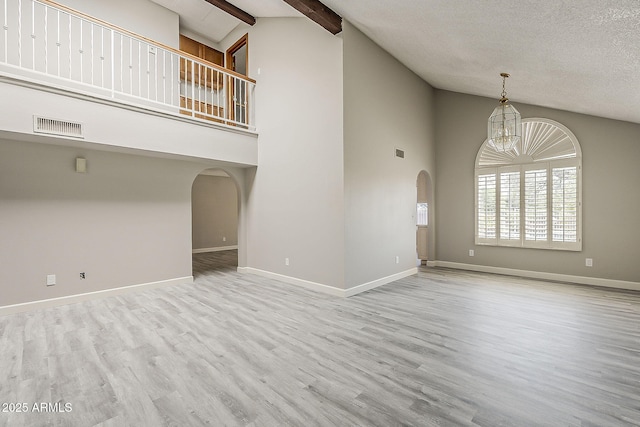 4627 E Mcneil St, Phoenix, AZ 85044 - unfurnished living room with arched walkways, high vaulted ceiling, wood finished floors, baseboards, and a chandelier
