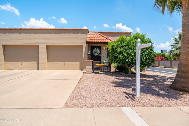 4501 E Carol Ave Unit 77, Mesa, AZ 85206 - view of front of property with an attached garage, concrete driveway, a tiled roof, and stucco siding