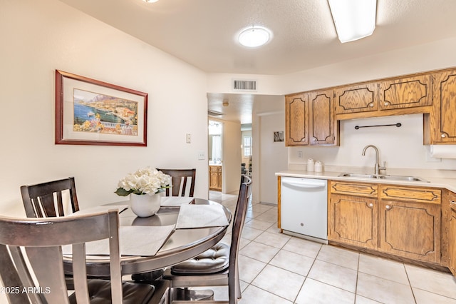 4501 E Carol Ave Unit 77, Mesa, AZ 85206 - kitchen featuring white dishwasher, a sink, light countertops, light tile patterned floors, and brown cabinets