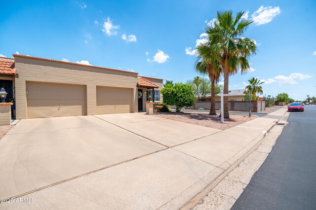 4501 E Carol Ave Unit 77, Mesa, AZ 85206 - view of front of property featuring driveway, a garage, a tiled roof, and stucco siding