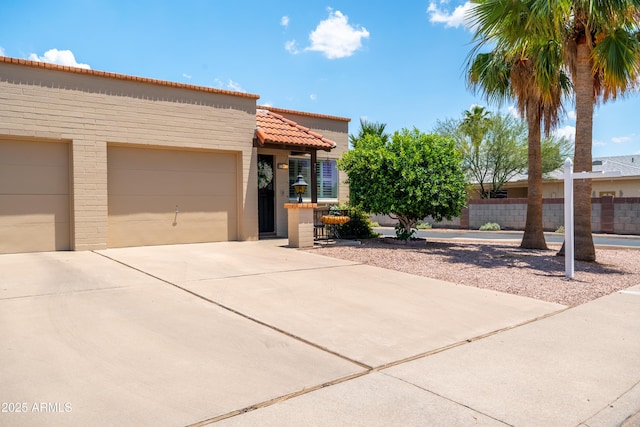 4501 E Carol Ave Unit 77, Mesa, AZ 85206 - view of front of house with concrete driveway, a garage, a tile roof, and stucco siding
