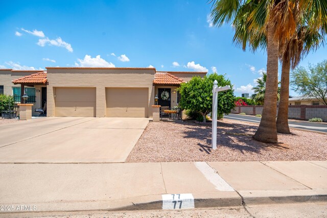 4501 E Carol Ave Unit 77, Mesa, AZ 85206 - view of front of property with a tile roof, an attached garage, driveway, and stucco siding