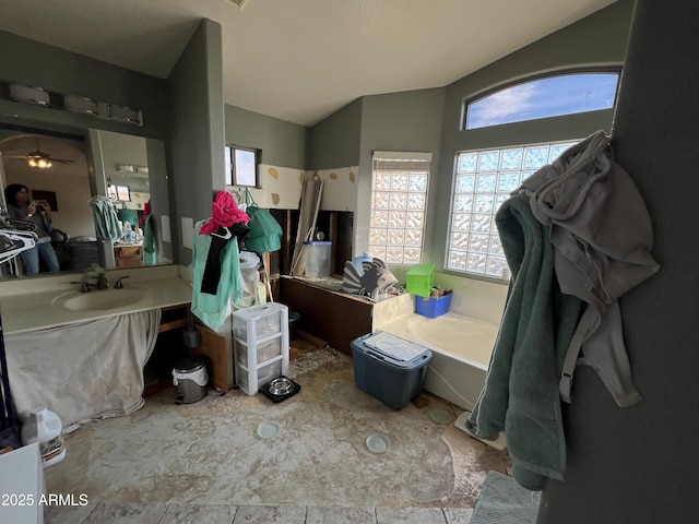 full bathroom featuring a garden tub, vaulted ceiling, and vanity