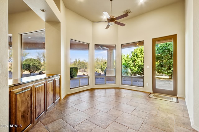 unfurnished sunroom with plenty of natural light and ceiling fan