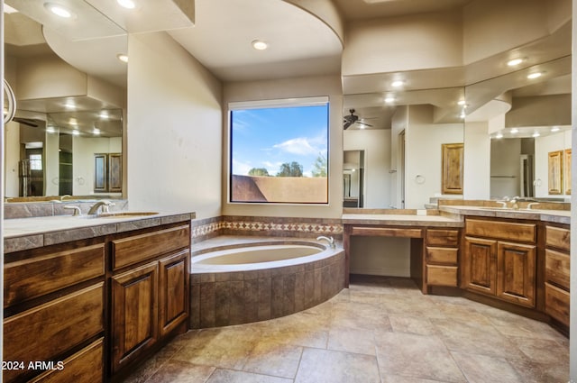 bathroom featuring ceiling fan, vanity, and tiled tub