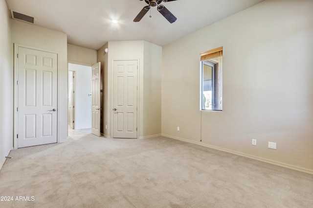 unfurnished bedroom featuring ceiling fan and light colored carpet