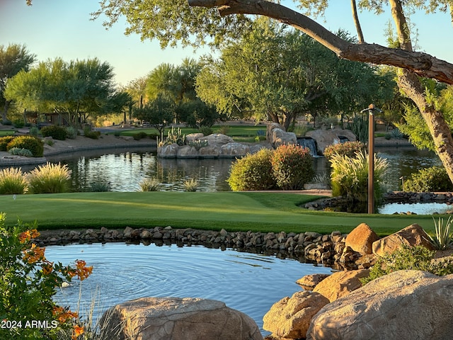 view of home's community with a lawn and a water view