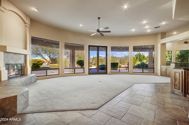 living room with a fireplace, light colored carpet, and ceiling fan