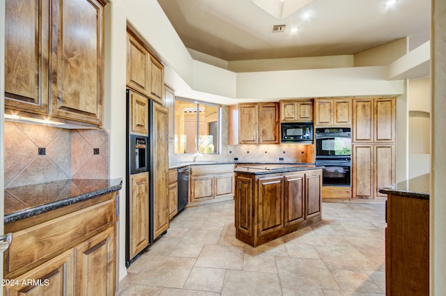 kitchen featuring backsplash, a kitchen island, black appliances, and light tile patterned floors