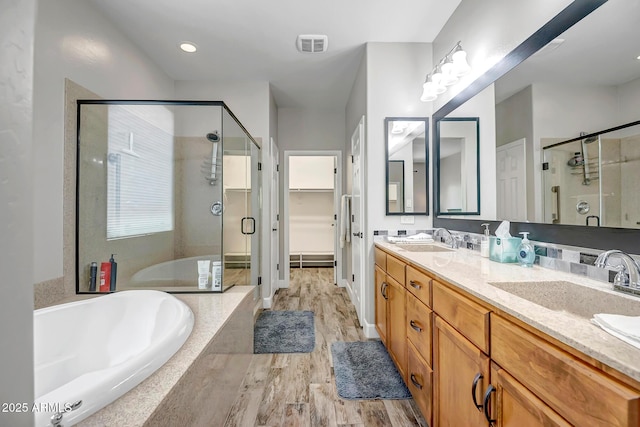 16426 W Piccadilly Rd, Goodyear, AZ 85395 - full bathroom featuring a stall shower, a bath, double vanity, and wood finished floors