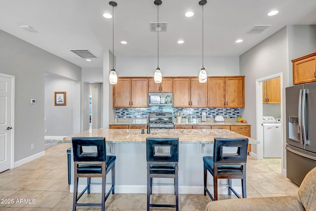 16426 W Piccadilly Rd, Goodyear, AZ 85395 - kitchen featuring stainless steel appliances, decorative backsplash, light stone counters, and recessed lighting