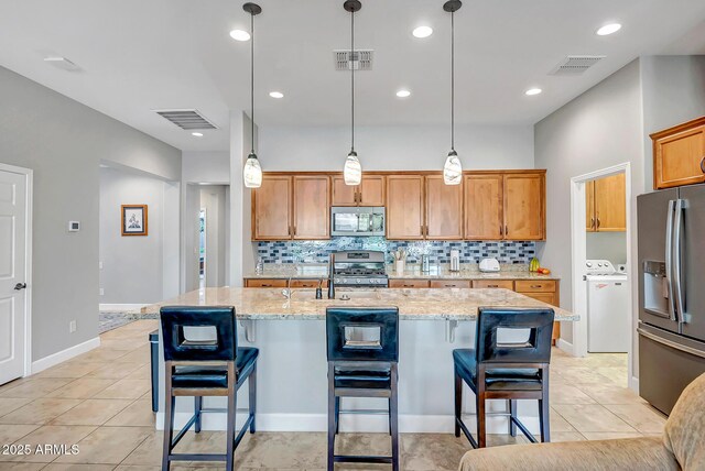 16426 W Piccadilly Rd, Goodyear, AZ 85395 - kitchen featuring stainless steel appliances, decorative backsplash, light stone counters, and recessed lighting