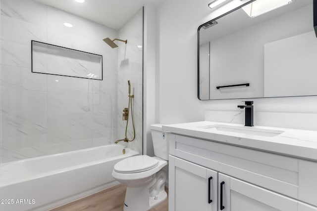 full bathroom featuring toilet, tiled shower / bath combo, wood-type flooring, and vanity