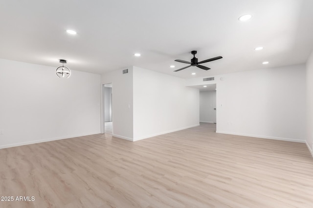 empty room with ceiling fan and light hardwood / wood-style flooring