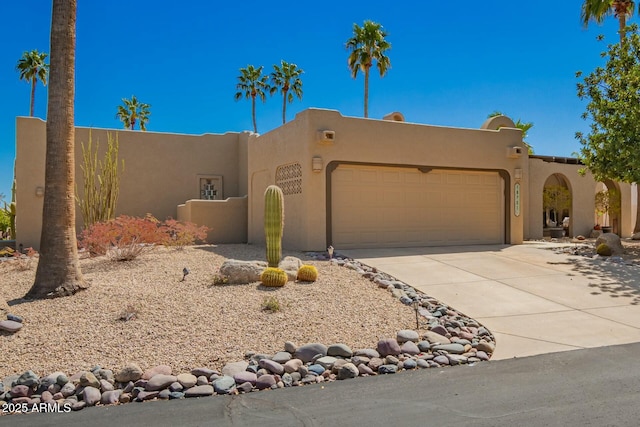 18701 E Mazatzal Cir, Rio Verde, AZ 85263 - pueblo revival-style home featuring a garage, concrete driveway, and stucco siding