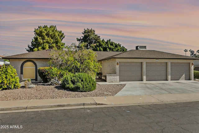 view of front facade with a garage, brick siding, and concrete driveway
