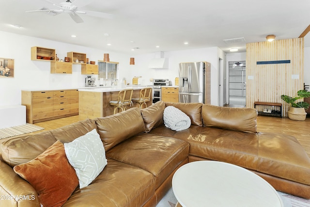 living room with ceiling fan, recessed lighting, and light wood-style floors