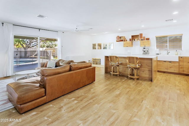 living area featuring visible vents, ceiling fan, light wood-style flooring, and recessed lighting