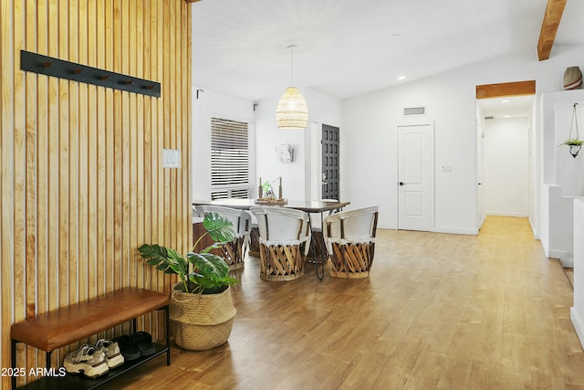 dining space featuring vaulted ceiling with beams, light wood-style floors, and visible vents