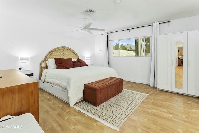 bedroom with a ceiling fan, light wood-style floors, and visible vents