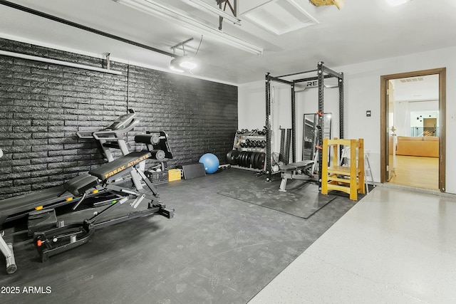 exercise area featuring a garage and brick wall