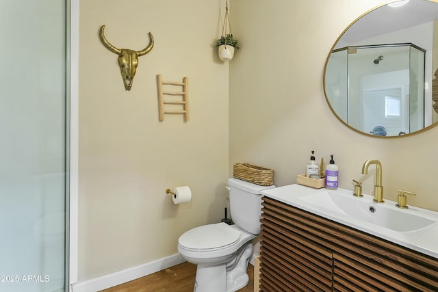 full bath featuring toilet, vanity, an enclosed shower, wood finished floors, and baseboards