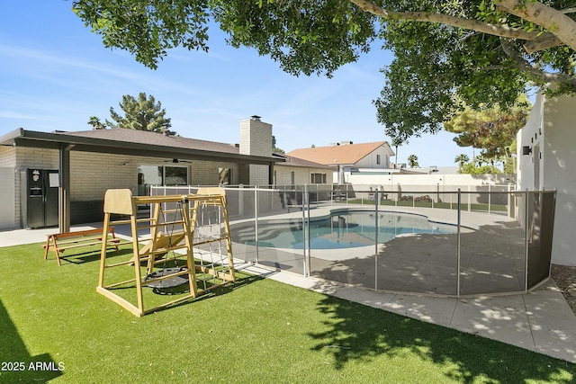 view of swimming pool featuring a lawn, a fenced in pool, a fenced backyard, and a patio area