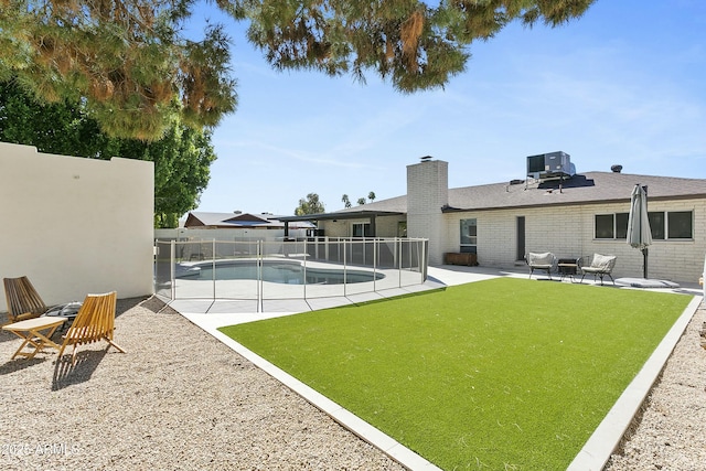 view of yard with a fenced in pool, central AC, fence, and a patio area