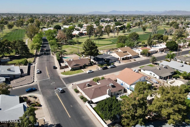 drone / aerial view with golf course view, a mountain view, and a residential view