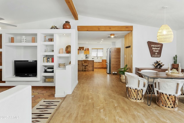 living room featuring lofted ceiling with beams, built in features, and light wood finished floors