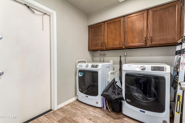 laundry room with cabinets, separate washer and dryer, and light hardwood / wood-style floors