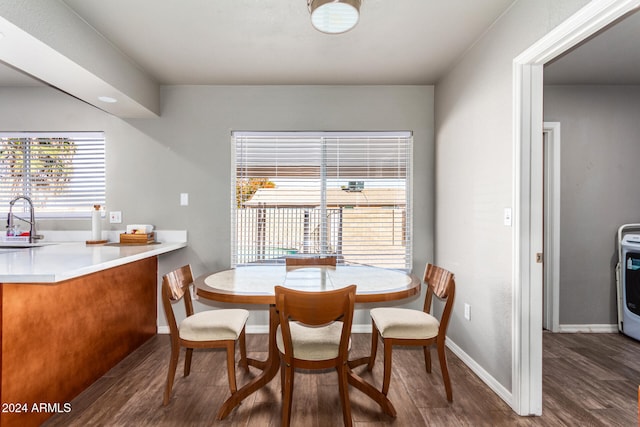 dining area with dark hardwood / wood-style flooring, sink, and washer / dryer