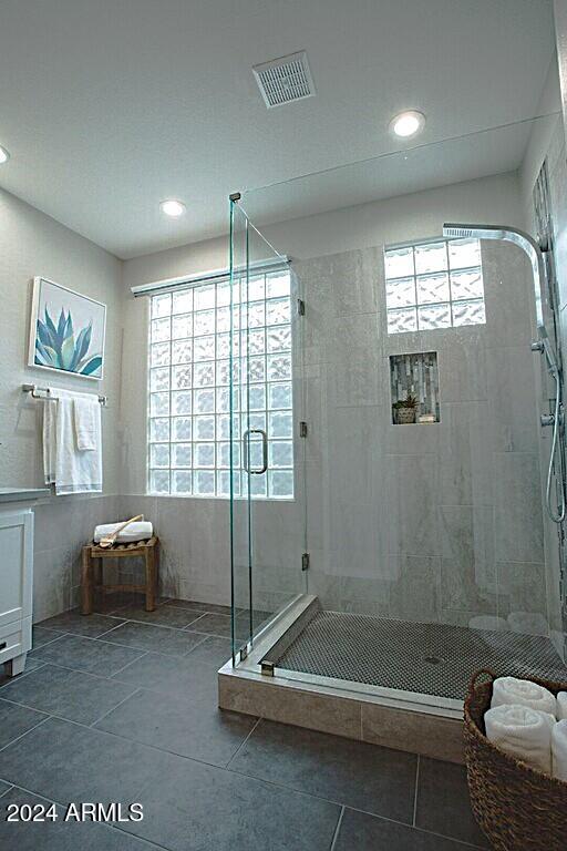 bathroom with tile patterned floors and a shower with shower door