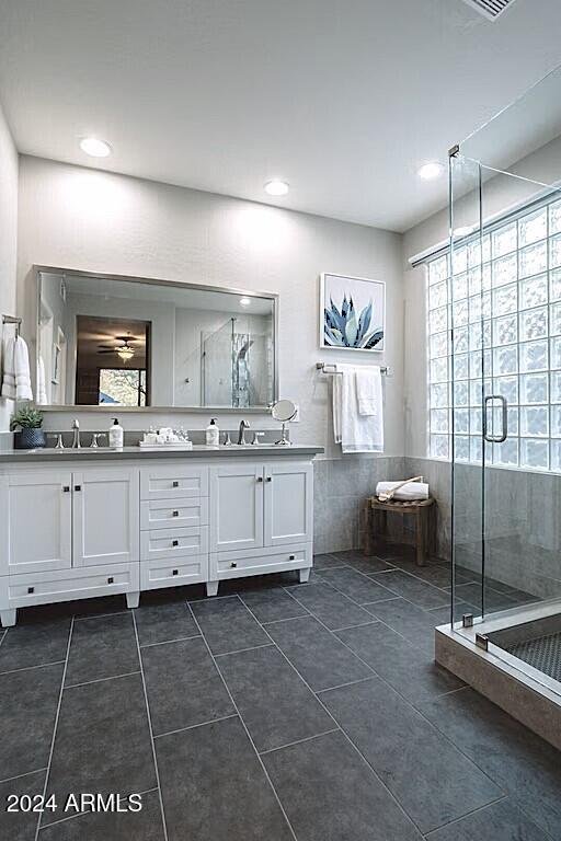 bathroom with tile walls, vanity, tile patterned floors, and a shower with shower door