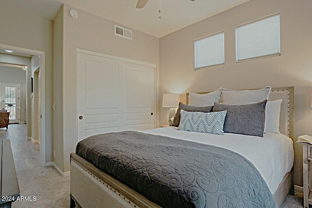 carpeted bedroom with ceiling fan and a closet