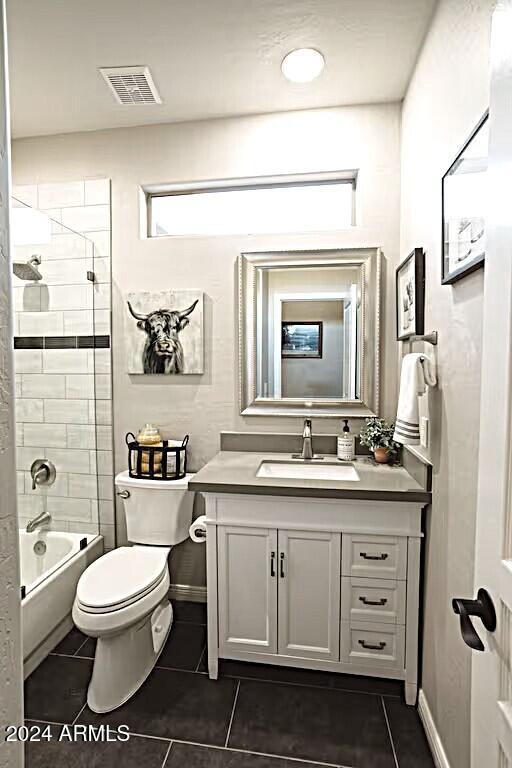 full bathroom featuring toilet, tiled shower / bath combo, vanity, and tile patterned flooring