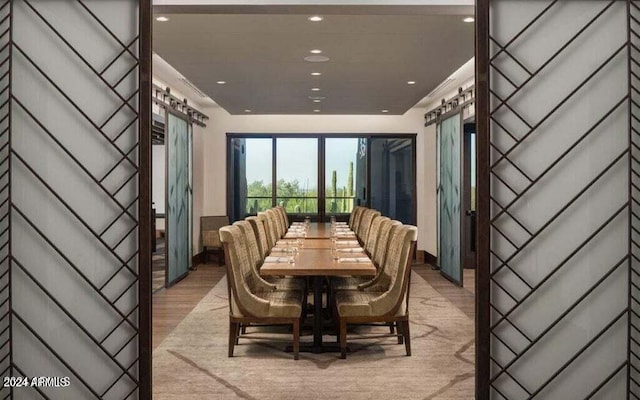 dining space featuring light hardwood / wood-style floors and a barn door