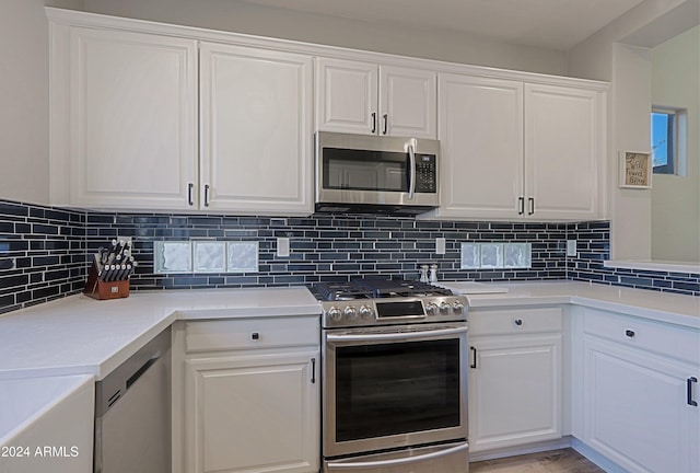 kitchen featuring light hardwood / wood-style floors, white cabinetry, backsplash, and appliances with stainless steel finishes