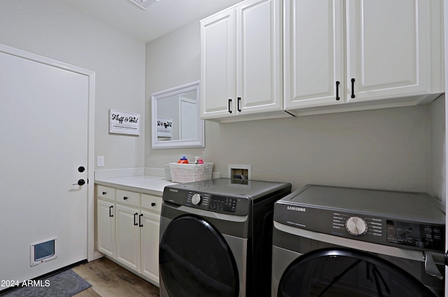 laundry area with separate washer and dryer, cabinets, and light wood-type flooring