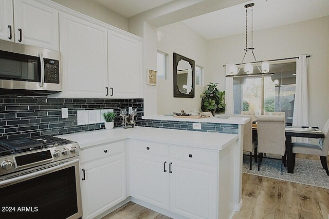 kitchen with kitchen peninsula, appliances with stainless steel finishes, light hardwood / wood-style flooring, white cabinets, and pendant lighting