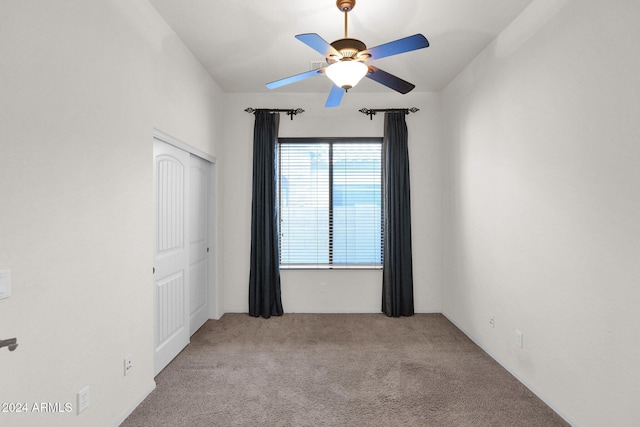 spare room with light colored carpet and ceiling fan