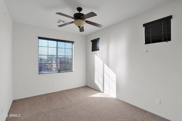 unfurnished room featuring light carpet, ceiling fan, and visible vents