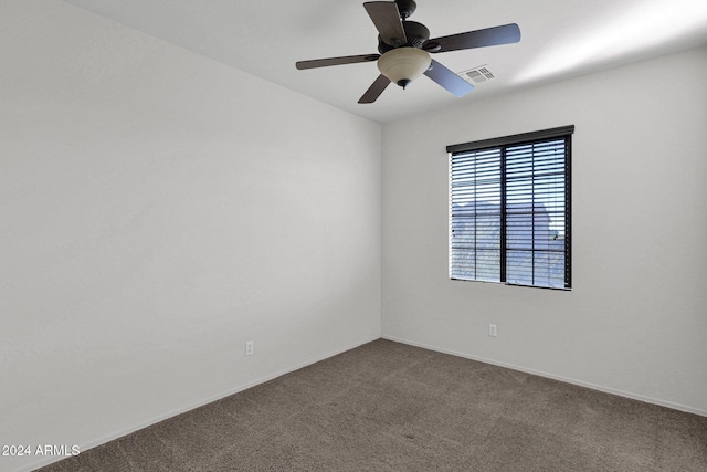 carpeted spare room with visible vents and a ceiling fan