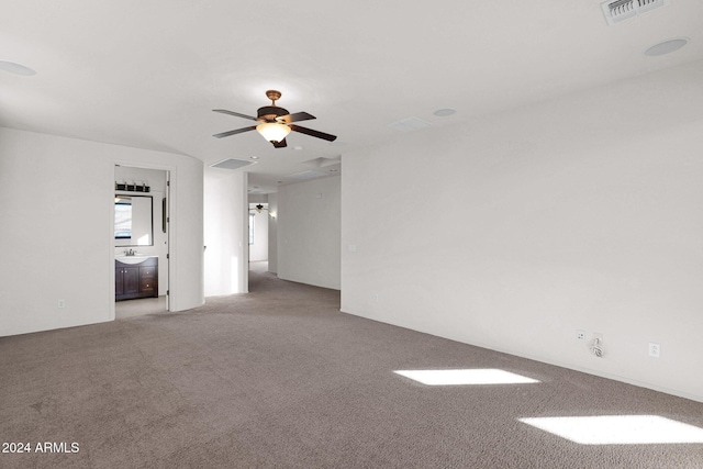 unfurnished room with ceiling fan, visible vents, a sink, and light colored carpet