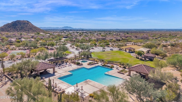 community pool with a patio area, fence, a mountain view, and a gazebo